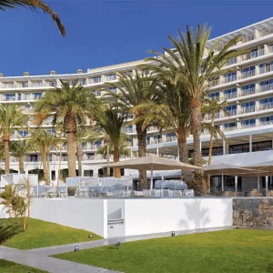 Die Frontansicht des Paradisus by Melia in Gran Canaria mit Palmen im Vordergrund.